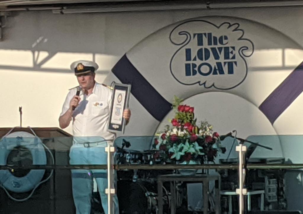 Captain with world record plaque, final count 1,425 couples