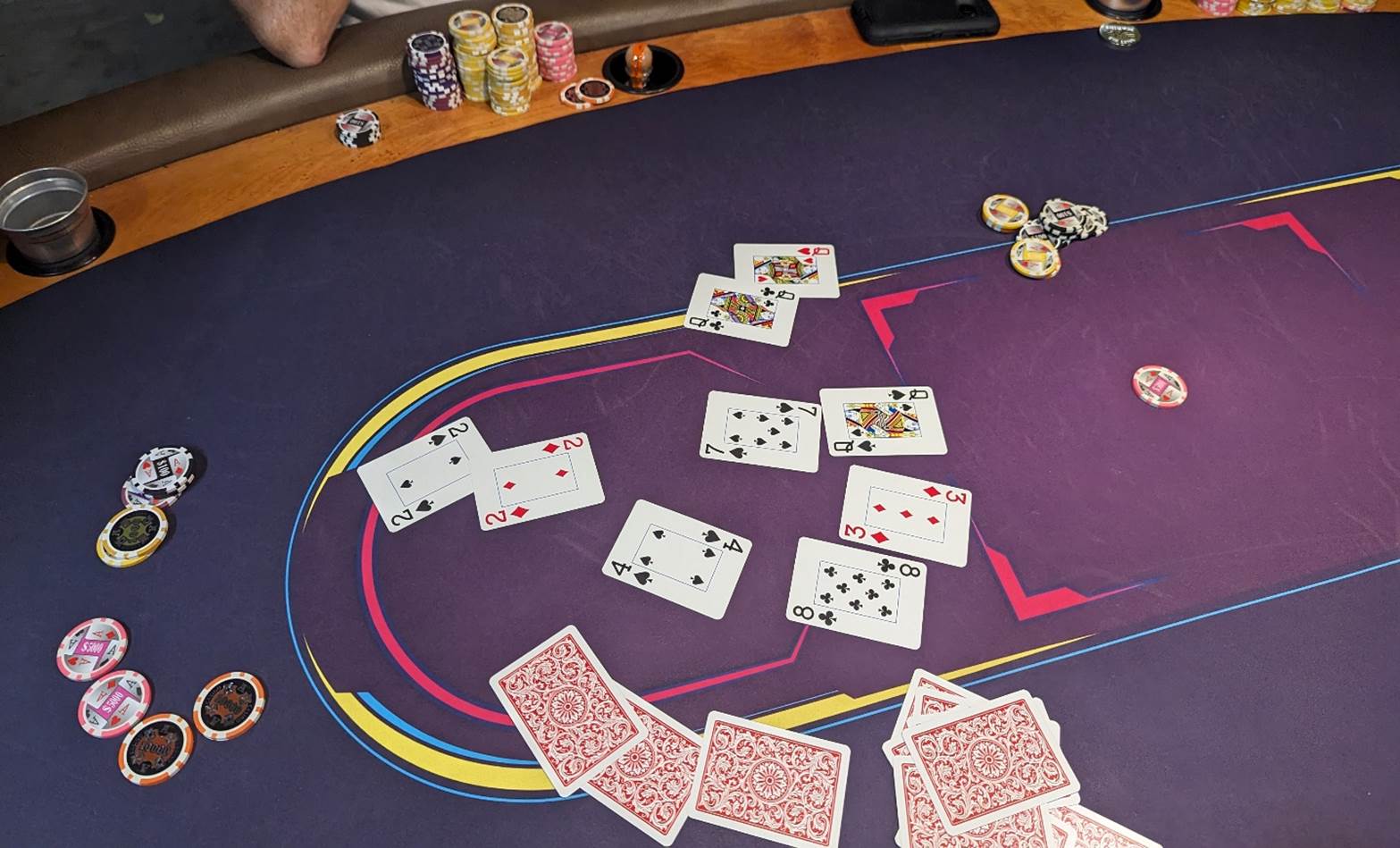 A poker table with cards and chips

Description automatically generated