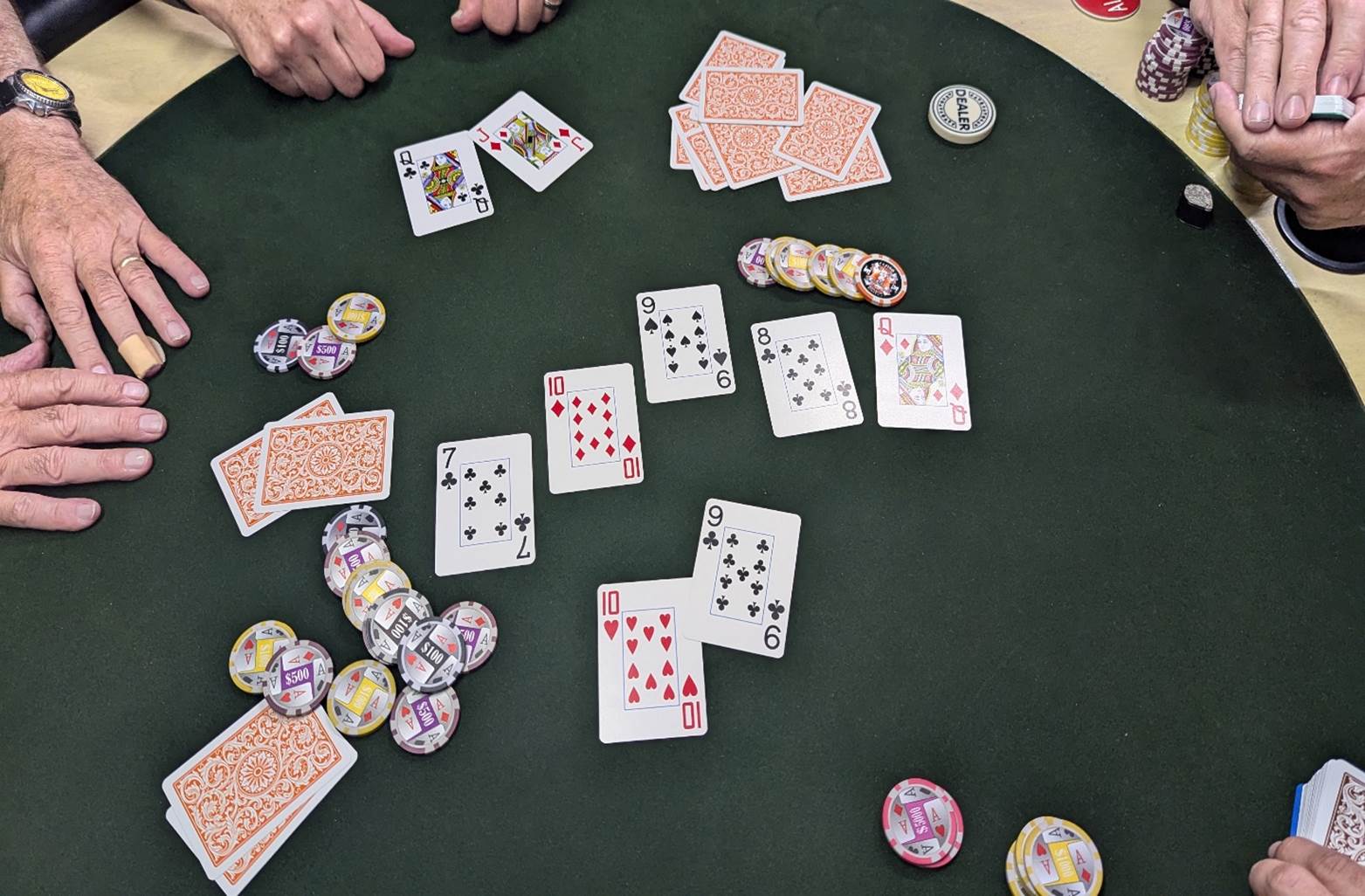 A poker table with cards and chips

Description automatically generated